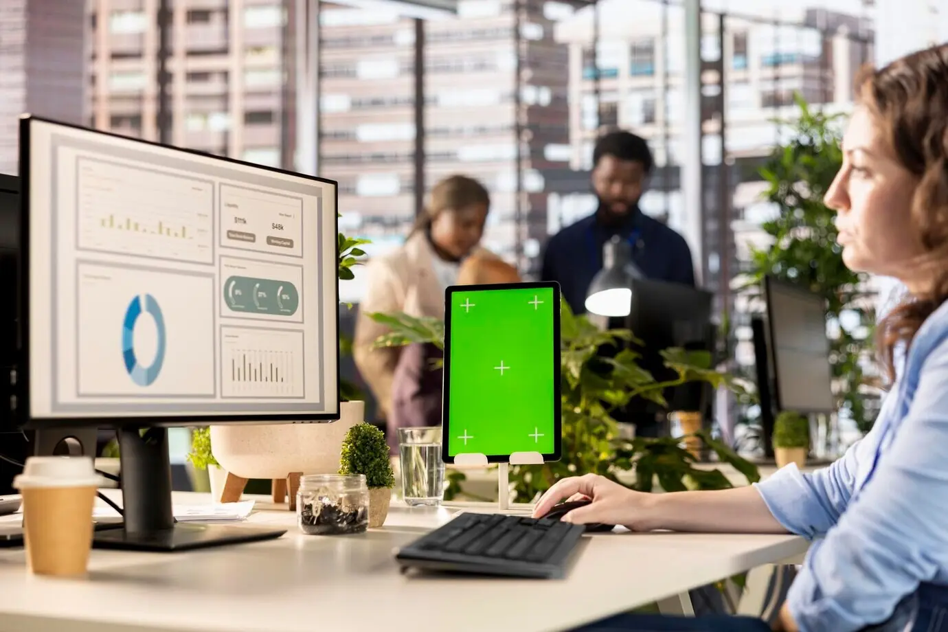 В корпорации профессиональный сотрудник работает за столом с зелёным экраном.